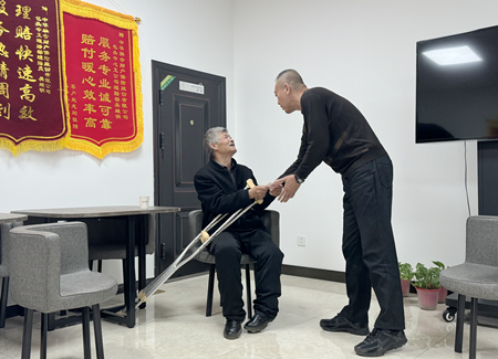 客户刘润根（左）向保险公司工作人员表示感谢.png