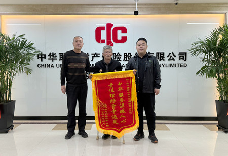 客户刘润根（左）向保险公司送来锦旗以示感谢.jpg